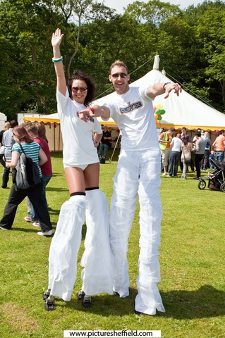Two people on stilts in Endcliffe Park during Gay Pride Festival