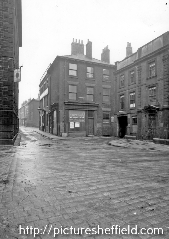 Hartshead looking towards Campo Lane, No. 1 R. Clift Horner, auctioneer and estate agent, No. 3, Broadbent House, also known as 'The Old Banker's House', right, St. Peter's Close under arch, East Parade Hotel (with gas lamp)