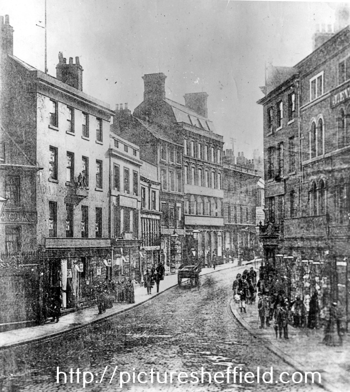 High Street from Market Place, before the street widening of 1896, premises include No 64A, High Street, India Rubber, Gutta-Percha, No 52-56 John Walsh, draper, Clarence Hotel in background (tallest building), No 55, Market Place, J. Evans, confecti