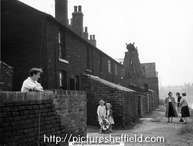 Mr. Vincent Lawrence Bryan with his children Stephen John; Kathleen and Pauline Mary in front of Nos. 7-12, Canal Cottages, Tinsley Park Road (demolished 1958) with the Sheff and SYK Navigation right