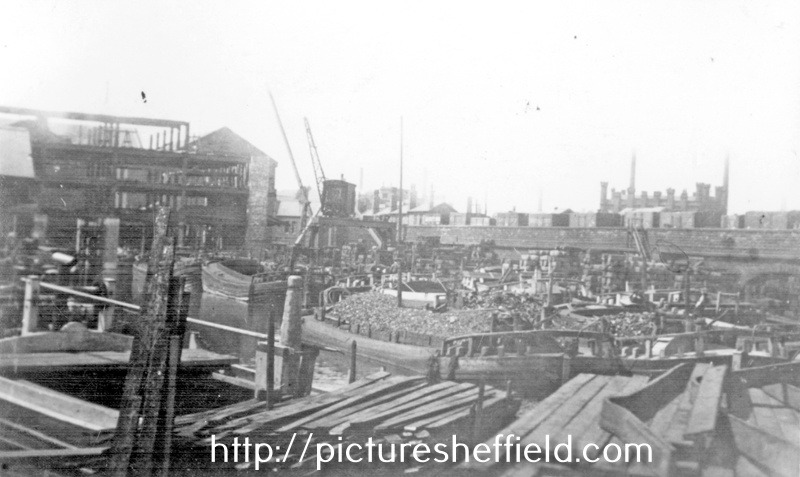 Sheffield Canal Basin with the construction of the Straddle Warehouse in the background. Tower Grinding Wheel, right