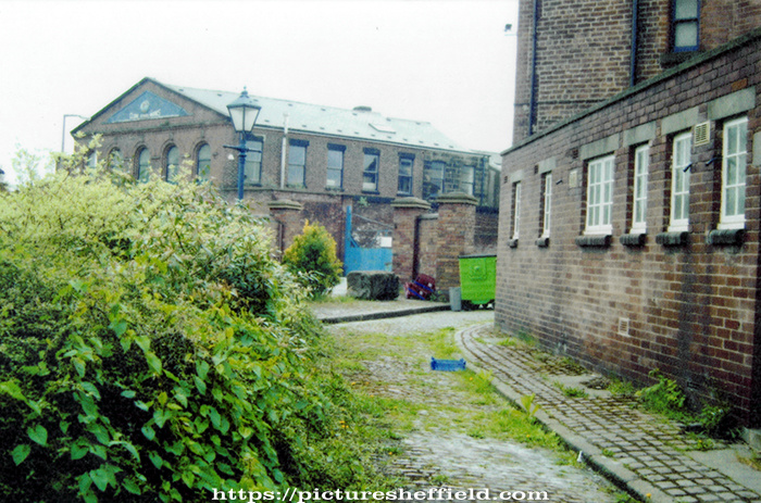 Cotton Mill Walk, from the Court entrance looking towards Alma Street with the Fat Cat public house left and the Globe Steel Works in the background