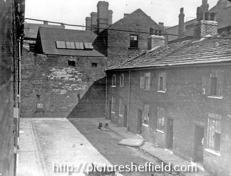 Looking towards the wall belonging to F.J. Brindley and Sons, Central Hammer Works, from Mate's Square, off River Lane, showing slum back to back housing
