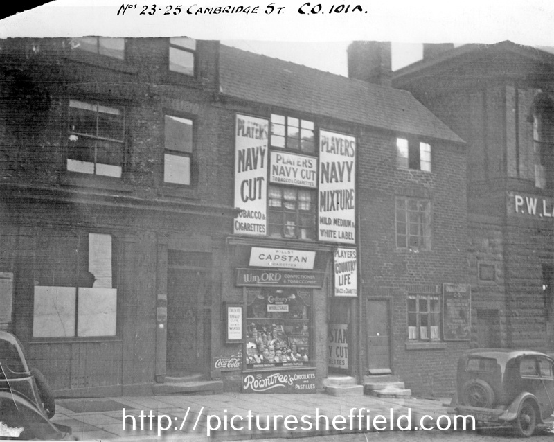 Nos. 21 - 25 Cambridge Street. No. 21 former Wellington Tavern, left, No. 23 Wm. Ord, confectioner and premises belonging to Percy W. Lacey (former St. Paul's School)