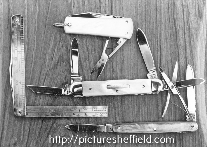 Three Pearl Pocket Knives, a lobster key-ring pattern; a four blader, including nail file and one with 2 blades and scissors in grey pearl, made by Stanley Shaw, cutler, 48 Garden Street a rule knife provides the scale
