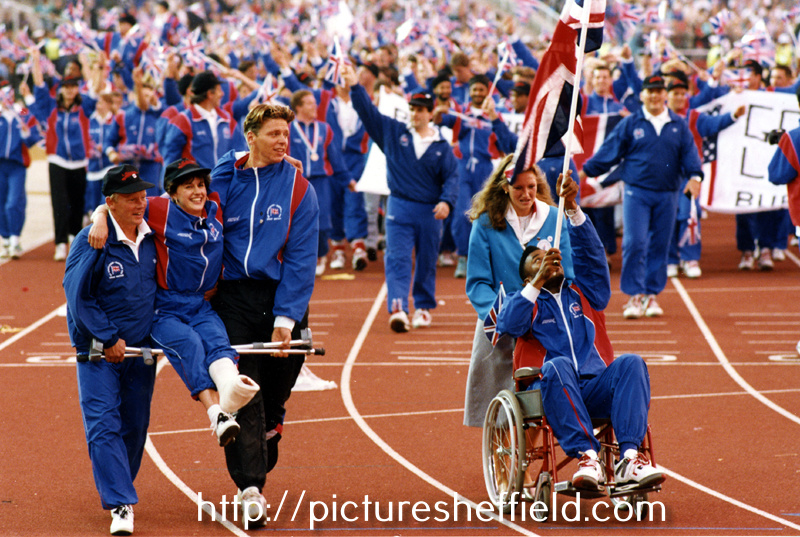 Great Britain Team Captain, javelin thrower Steve Backley assists an injured fellow Team Member at the Closing  Ceremony, World Student Games, Don Valley Stadium