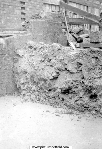 Sheffield Castle excavations recorded by J.B. Himsworth. Newly concreted excavation, burying the plinth of tower and several courses of masonry