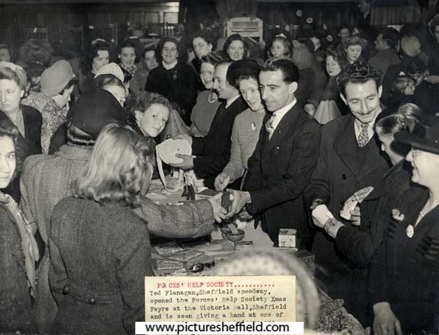 Ted Flanagan, Sheffield speedway, opens the Forces' Help Society Christmas Fayre at the Victoria Hall, Sheffield and is seen giving a hand at one of the stalls