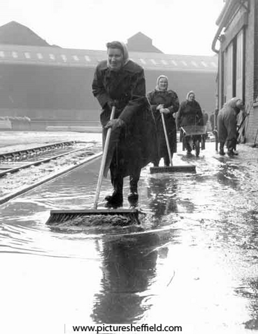Clearing up after flooding caused by torrential rain outside English Steel Corporation's River Don Works, Brightside Lane.