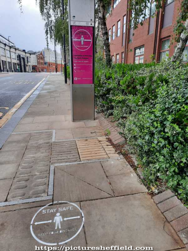Covid-19 pandemic: bus stop information board and social distancing markings on path, Paternoster Row