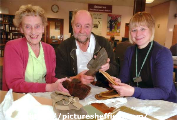 Cheryl Bailey, Senior Archivist (right) with Barbara Neill (left), Archives and Local Studies Dept., No. 54 Shoreham Street and Rony Robinson (BBC Radio Sheffield) looking at Edward Carpenter's sandals