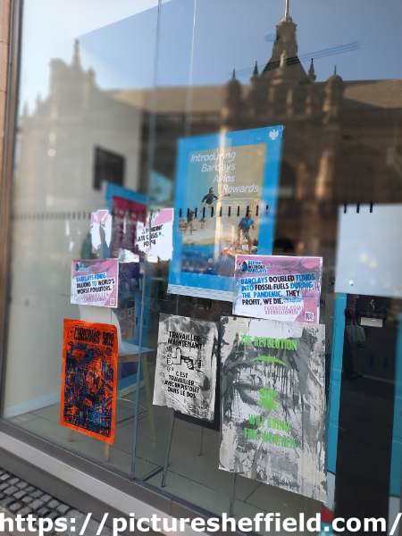Barclays Bank, Pinstone street - Extinction Rebellion (XR) window posters protesting against the bank's investment in fossil fuels