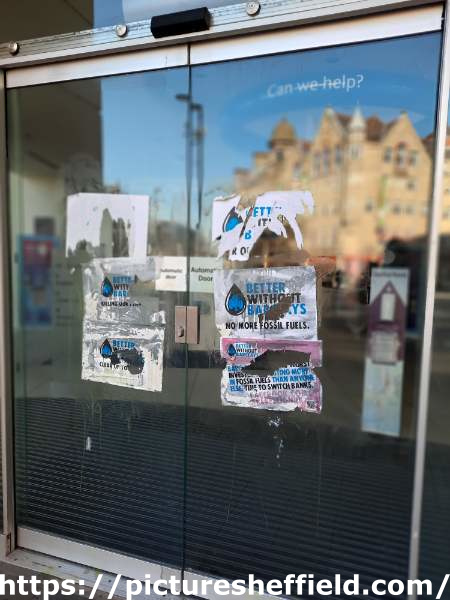 Barclays Bank, Pinstone street - Extinction Rebellion (XR) window posters protesting against the bank's investment in fossil fuels