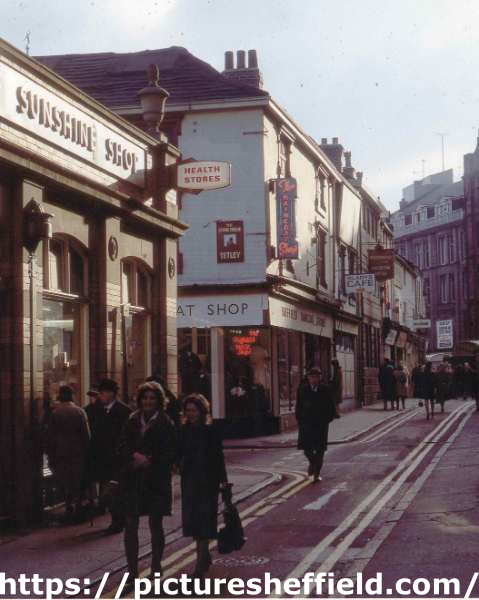 Orchard Street showing (left) No. 15 The Sunshine Shop (Sunshine Foods Ltd.), health food shop and (centre) No. 21 Sheffield Raincoat Stores