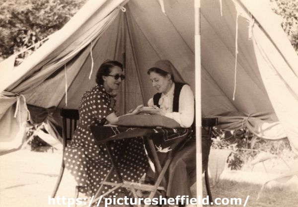 May Mirfin (1901-1994) [former Sheffield ARP ambulance driver and later Sheffield Civil Defence member] carrying out 'gypsy fortune telling' in a tent at a Sheffield Civil Defence Garden Party, c. 1950