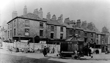 Shops on Barkers Pool known as Pool Place, prior to demolition in preparation for the War Memorial, note the 'Iron Man' Public lavatory. Holly Street, left