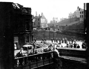 Air raid damage at Pond Hill Bridge, junction of Pond Hill and Sheaf Street. Sun Inn, junction of South Street and Gilbert Street, Park, in background 	
