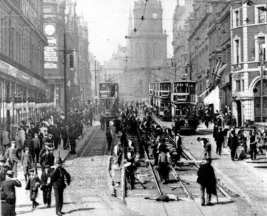 Re-laying the tram-tracks on Pinstone Street at Moorhead, Nelson Hotel, right (with flag). St. Paul's in distance