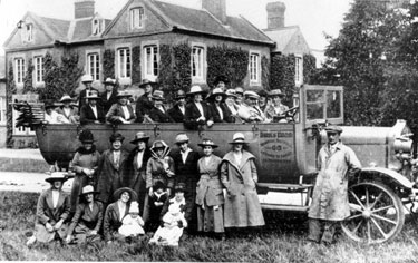 Charabanc belonging to Birks Bros. of Woodhouse, on a trip to the Dukeries, Ken Birks in driving seat. Ron Birks leaning against front wing, bus has solid tyres