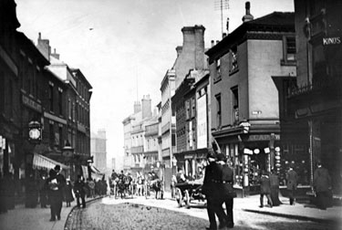 High Street at junction with George Street, shops on right include No. 34 (and No. 2 George Street), Charles Kino, tailor, No 36 and 38, H. Hawksley, hatter and Queen Victoria Hotel (entrance on George Street), No 31, Old Blue Bell, left (wher