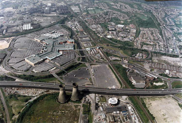 Aerial view of Meadowhall Shopping Centre and surrounding area. The M1 Tinsley Viaduct cuts across the bottom of the picture leading to junction 34 in the bottom right-hand corner. Former cooling towers of Blackburn Meadows Power Station in foregrou