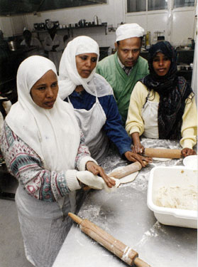 Group of women making chapattis at the Pakistan Muslim Centre, Woodbourn Road