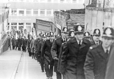 Police marching from Campo Lane up Vicar Lane during the Miners Strike with Silverstones Ltd. in the background