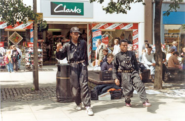 Patrick Monrose and Regis Dulace, members of the Paris based Pop Dream Company entertaining outside Clarks shoe shop, No. 16, Fargate during the World Student Games, Cultural Festival