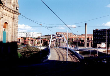 Park Square Supertram Bridge, at bottom of Commercial Street, during the construction of Supertram. Hyde Park Flats, left, and Park Hill Flats, right, in background
