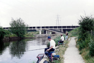 Fishing the Sheffield and South Yorkshire Navigation with the footbridge linking the Arena, Broughton Lane and Greenland Road and Broughton Lane Bridge in the background