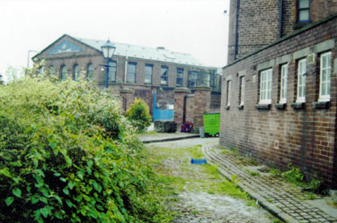 Cotton Mill Walk, from the Court entrance looking towards Alma Street with the Fat Cat public house left and the Globe Steel Works in the background