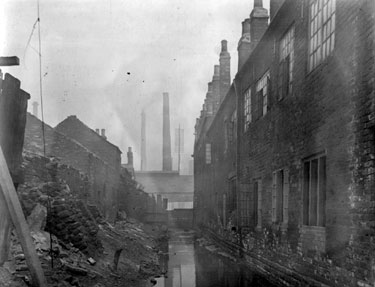Goit between remains of J. Chantrey's Milk Yard (approached via River Lane), left, and Sheaf Island Works (Steel and Iron), right, looking towards Pond Hill