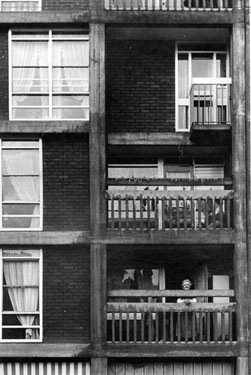Lady looking out over the balcony at Park Hill Flats