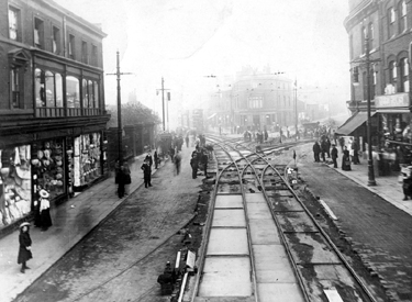 Laying of tram tracks at bottom of South Street, Moor, looking towards junctions with London Road (left), Cemetery Road (centre) and Ecclesall Road (right), Nos 215-221, James Lamb and Son, Drapers, left, railings on left belong to Brunswick Wesl