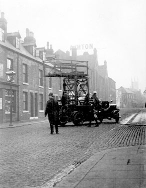 Sidney Street outside Thomas A. Ashton Ltd., looking towards Sylvester Street with St. Mary's, Bramall Lane in the background