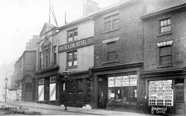 Shops at Barkers Pool, from Pool Square, prior to demolition for the War Memorial, (l. to r.), No. 116 New Music Hall Tavern; No. 114 John Hoyland and Son, pianoforte dealers; No. 110 White Lion Hotel; No. 108 Mazzini Cadman, secondhand bookseller 