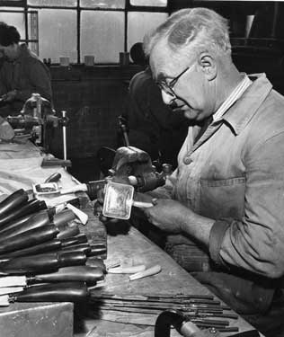 Expert at producing carving knives with buffalo horn handles at his work bench, Lewis, Rose and Co.Ltd., cutlery manufacturers, Debesco Works, Bowling Green Street