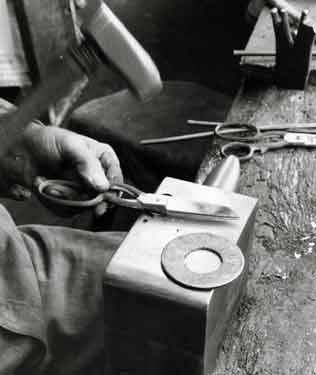 Mr H. Whitehead, putting together the second stage in the assembly of a pair of scissors, Frank Turton Ltd., scissor manufacturer, No.72 Arundel Street