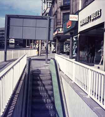 Escalator on High Street to subway showing (right) No.41, Polly of Picacadilly, costumiers and No.43 Swears and Wells Ltd., furnishers