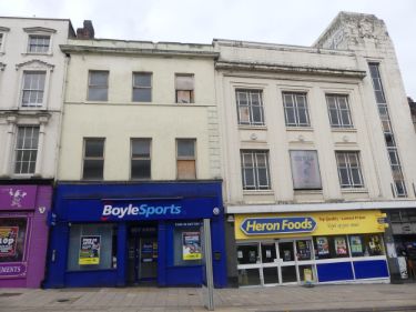 Shops on Haymarket showing (left) No. 17 Boyle Sports, bookmakers and (right) Nos. 19 - 21 Heron Foods, discount supermarket
