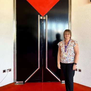 Sheffield Theatres' Front of House Manager, Debbie Fairest, standing by the Crucible Theatres' famous red door, where she was stationed on the night of the iconic Black Ball Final at the 1985 World Snooker Championships