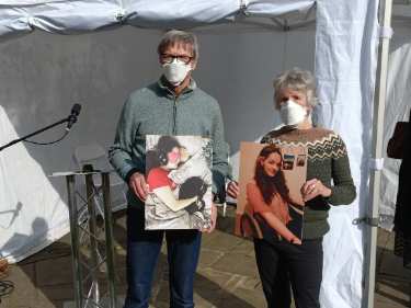 Parents of Fran Haddock, a sufferer from Long Covid, listening to her recorded message, Covid Memorial Day, 2025 in Balm Green Gardens
