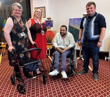 Learning Disability Week - Marie (Expert by experience), Terri-Leigh (Co chair of Sheffield Learning Disabilities Partnership Board), Marcus (Sheffield Voices), Neil (Project Co-ordinator at Sheffield Voices) in front of Learning Disability artwork