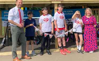 Councillor Ben Miskell, Chair of the Transport, Regeneration and Climate Policy Committee at Sheffield City Council and Sarah Bins, headteacher of Stannington Infants School with pupils at the unveiling of their new bike barn