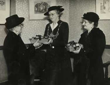 Lady Mayoress, Mrs Marshall presenting baskets of fruit to Mrs Mason and Mrs Flannery, 2 of 3 buffer girls chosen 50 years ago as models for panels in the Town Hall, Pinstone Street