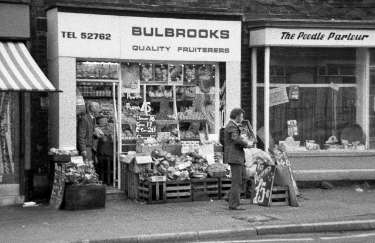 Shops on Abbeydale Road showing No. 555 Bulbrooks, fruiterers and No. 557 The Poodle Parlour, pet stores, mid 1970s