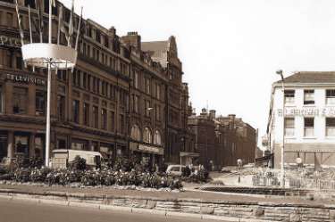 View of Leopold Street from Fargate showing (foreground) Goodwin Fountain and (l. to r.) Wilson Peck, music warehouse, Beethoven House; Marshall and Snelgrove, fashion shop; Grand Hotel and Education Department offices