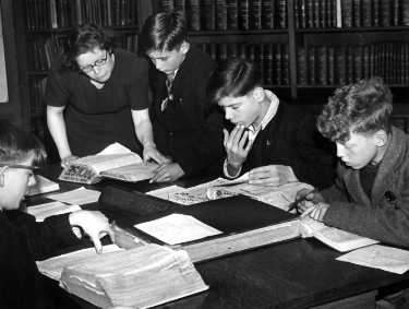 Miss Buchanan with a group of boys in the Commerce, Science and Technology Library, Central Library during school instruction