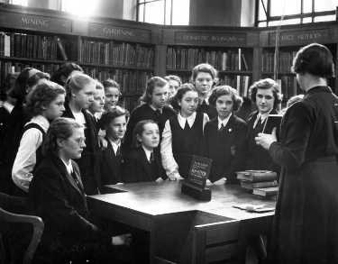 Miss Charlesworth with a group of girls in the Central Lending Library, Central Library during school instruction