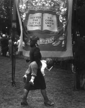 Salvation Army member with child under arms, with banner of City Gospel Mission